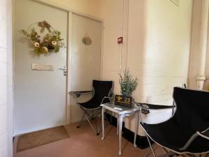 ein Raum mit zwei Stühlen und einem Tisch und einer Tür in der Unterkunft No23 - Bright & spacious 2nd floor flat - PET friendly - Noon check out in Stanwix + 16 Fotos