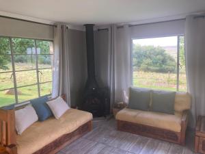 un salon avec un canapé et une cheminée dans l'établissement Mountain View Farm Cottage 4X4 Vehicles ONLY, à Dullstroom