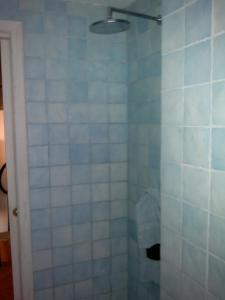 La salle de bains est pourvue d'une douche avec du carrelage bleu et blanc. dans l'établissement Torrione San Lorenzo I, à Terracine