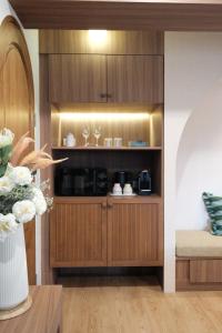 a living room with a cabinet with a coffee maker at The Shantipan Mandala - Cozy City Retreat 400m from BTS Station in Bangkok