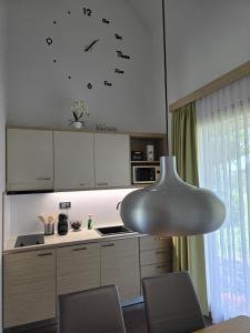 a kitchen with white cabinets and a table and chairs at Apartma Pikabooth in Topolšica +37 photos