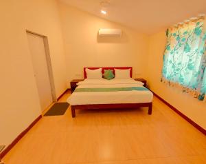 a bedroom with a bed and a painting on the wall at GreenHouse 5Bhk Villa Alibaug in Alibaug +4 photos