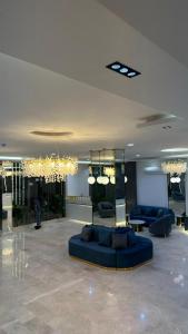 a living room with a blue couch in a lobby at دره الحفر للشقق الفندقيه2 - Durat Al Hafr 2 in Hafr Al Baten