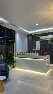 a lobby with a blue couch and a counter with vases at دره الحفر للشقق الفندقيه2 - Durat Al Hafr 2 in Hafr Al Baten