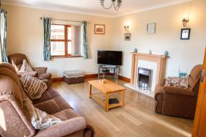 a living room with a couch and a tv at Aberystwyth Cottage Ilar in Llanilar