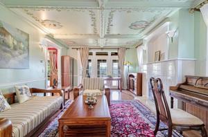 un salon avec un canapé et un piano dans l'établissement Emerald water vila in capital hill, à Seattle