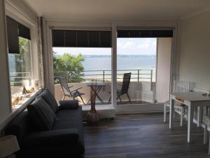 a living room with a couch and a view of the ocean at Inselblick am Meer in Glücksburg