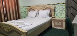 a bedroom with a bed with a wooden headboard at 7 Pir in Bukhara