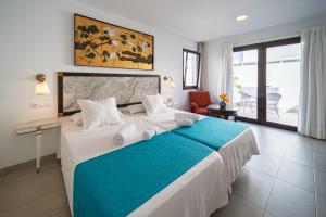 a bedroom with a large bed with a blue blanket at La Casona de Yaiza I Hotel Emblematico in Yaiza