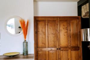 Saint-Jean-le-CentenierにあるMagnifique Appartement Climatisation Parking Gratuitの木製のキャビネットと鏡が備わる客室です。