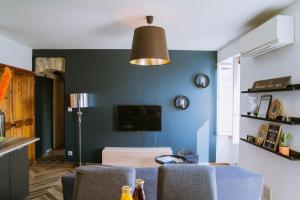 Saint-Jean-le-CentenierにあるMagnifique Appartement Climatisation Parking Gratuitの青い壁のリビングルーム(天井ファン付)