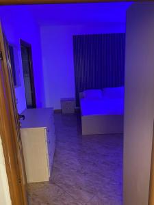 a blue room with a bed and a couch at Jaupaj Rent House in Vlorë +2 photos