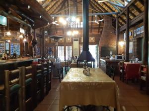 a restaurant with a table and chairs and a bar at Cranberry Cottage in Kathu