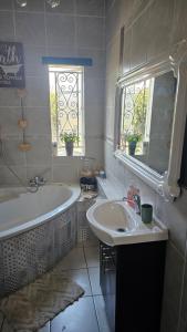 ein Badezimmer mit Badewanne und Waschbecken und einem Fenster in der Unterkunft Rose Cottage Vintage room in Pretoria + 12 Fotos