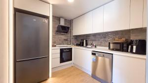 una cucina con armadi bianchi e frigorifero in acciaio inossidabile di Kundu Kanyon by AntalyaSuites a Antalya (Adalia)