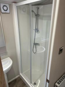 una cabina de ducha en un baño con lavabo en Autumn Lakefront Retreat - Free Fishing, en Amotherby