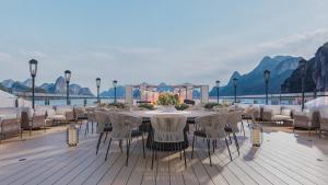 ハロンにあるDiana Cruises Halong Bayの山々を望むデッキに置かれたダイニングテーブルと椅子