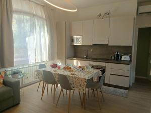a kitchen with a table and chairs and a kitchen with white cabinets at A Casa di Raffi by Holiday World in Pisogne