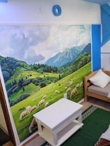 Un dormitorio con un mural de un campo verde de ovejas. en Retro II,  8 fotos más