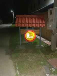 un cartel rojo al costado de una calle por la noche en Retro II, 