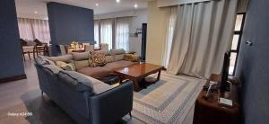 una sala de estar con un sofá y una mesa en Town houses, en Lusaka