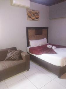 a bedroom with a bed and a couch in it at Garden point Guest house in Johannesburg