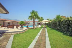 a backyard with a lawn and a swimming pool at Hotel la Fenice in Boscoreale