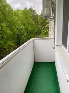 a balcony with a green floor and a window at Апарт Безручка in Rivne