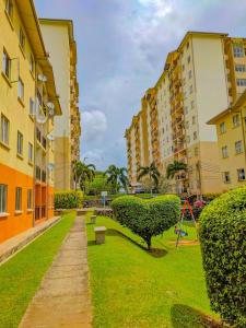 a park with a bush and a bench and buildings at Richmond Hill SHA Residencies in Galle