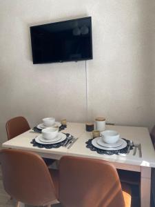 a table with two chairs and a tv on the wall at Апарт Безручка in Rivne