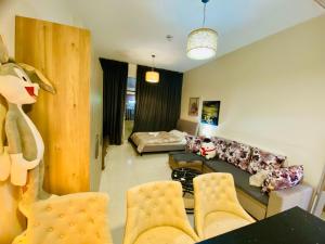 ein Wohnzimmer mit einer Couch und einem Bett in der Unterkunft Nice Studio for rent at Jumeirah Village Circle Dubai in Sabkhah
