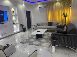 a large living room with couches and a tv at Murphy Apartments, Lekki in Lekki
