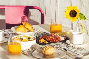 a table topped with plates of food and orange juice at La Casona de Yaiza I Hotel Emblematico in Yaiza