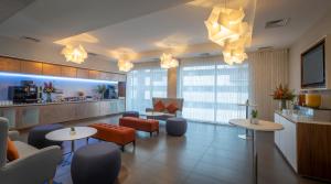 a hotel lobby with tables and chairs and a kitchen at Clayton Hotel Birmingham in Birmingham