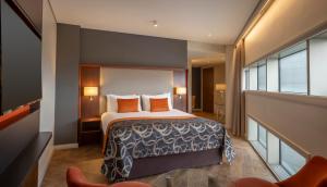 a hotel room with a bed with orange pillows at Clayton Hotel Birmingham in Birmingham +31 photos