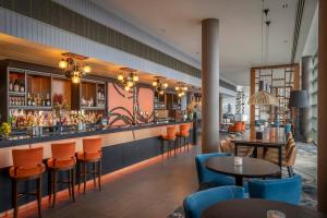 a bar in a restaurant with orange chairs and tables at Clayton Hotel Birmingham in Birmingham