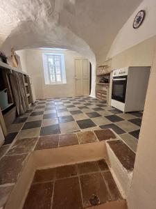 a kitchen with a checkered floor and an archway at Appartement villageois ou maison entière in Aniane