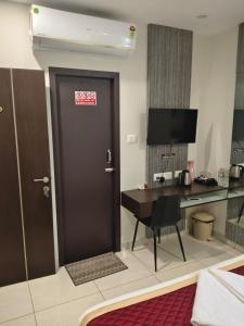 a room with a door with a desk and a computer at KK Grand Inn in Vellore +17 photos