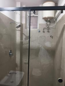 een badkamer met een douche met een glazen deur bij KK Grand Inn in Vellore +18 foto's