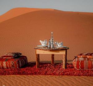 a table in the middle of a desert at Merzouga Marvelous Camp in Merzouga