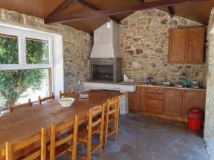 a kitchen with a wooden table and a stone wall at Casa Esmeralda in Borbén