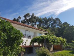 a house with a balcony and trees in the background at Casa Esmeralda in Borbén