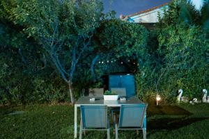 a table and two chairs in a yard at night at Olivea Residence by A&D Properties in Porto Rafti