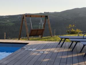 a wooden deck with a swing and a picnic table at Casa Esmeralda in Borbén