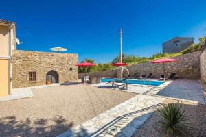 a patio with red umbrellas and a swimming pool at Villa Mediteran with private pool in Vrh