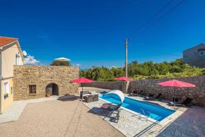 a house with a swimming pool and red umbrellas at Villa Mediteran with private pool in Vrh