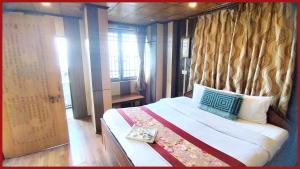 a bedroom with a large bed with a window at A Top Rated Hotel B-R-O-A-D-A-Y - Mall Road - Luxury & Spacious Room - Book Now in Darjeeling +10 photos