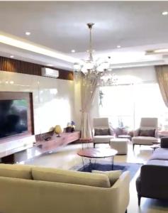 a living room with a couch and a tv and a chandelier at Elite Luxury Apartment in Lagos