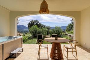 eine Terrasse mit einem Tisch und Stühlen sowie Aussicht in der Unterkunft Chambre d'hôtes avec jacuzzi proche Saint Tropez in Plan-de-la-Tour