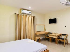 a room with a bed and a desk and a mirror at Motel Mốt in Danang